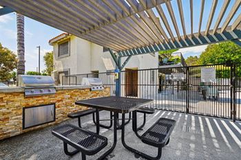A patio with a table and chairs under a roof.